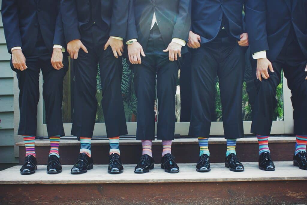 Men in formal wear showing off their colored socks