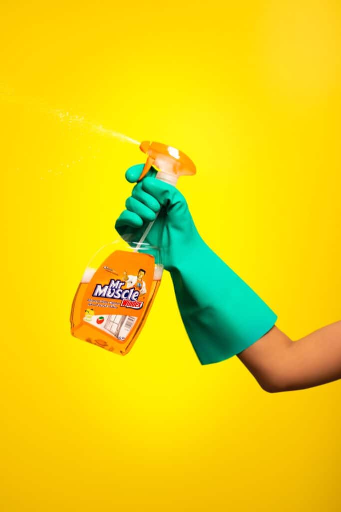 Person holding a Windex spray