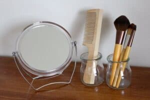 Espejo, peine de madera limpio y cepillos en una mesa