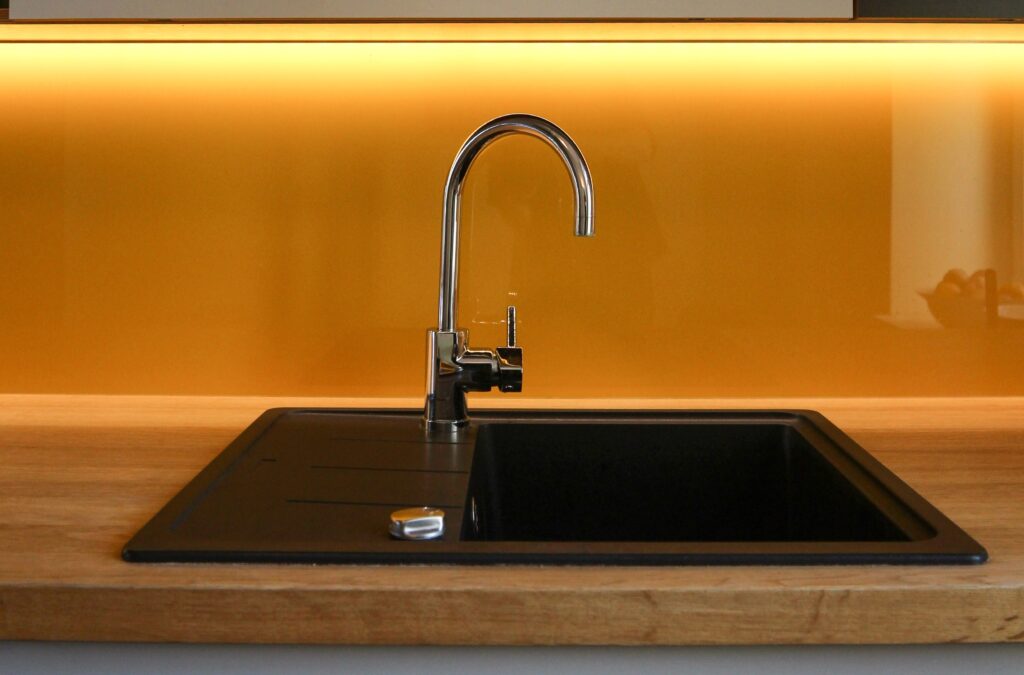 A black kitchen sink with orange lights