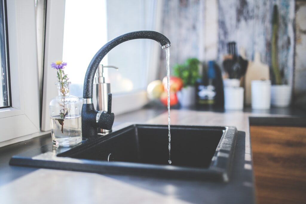 A black kitchen sink with running water