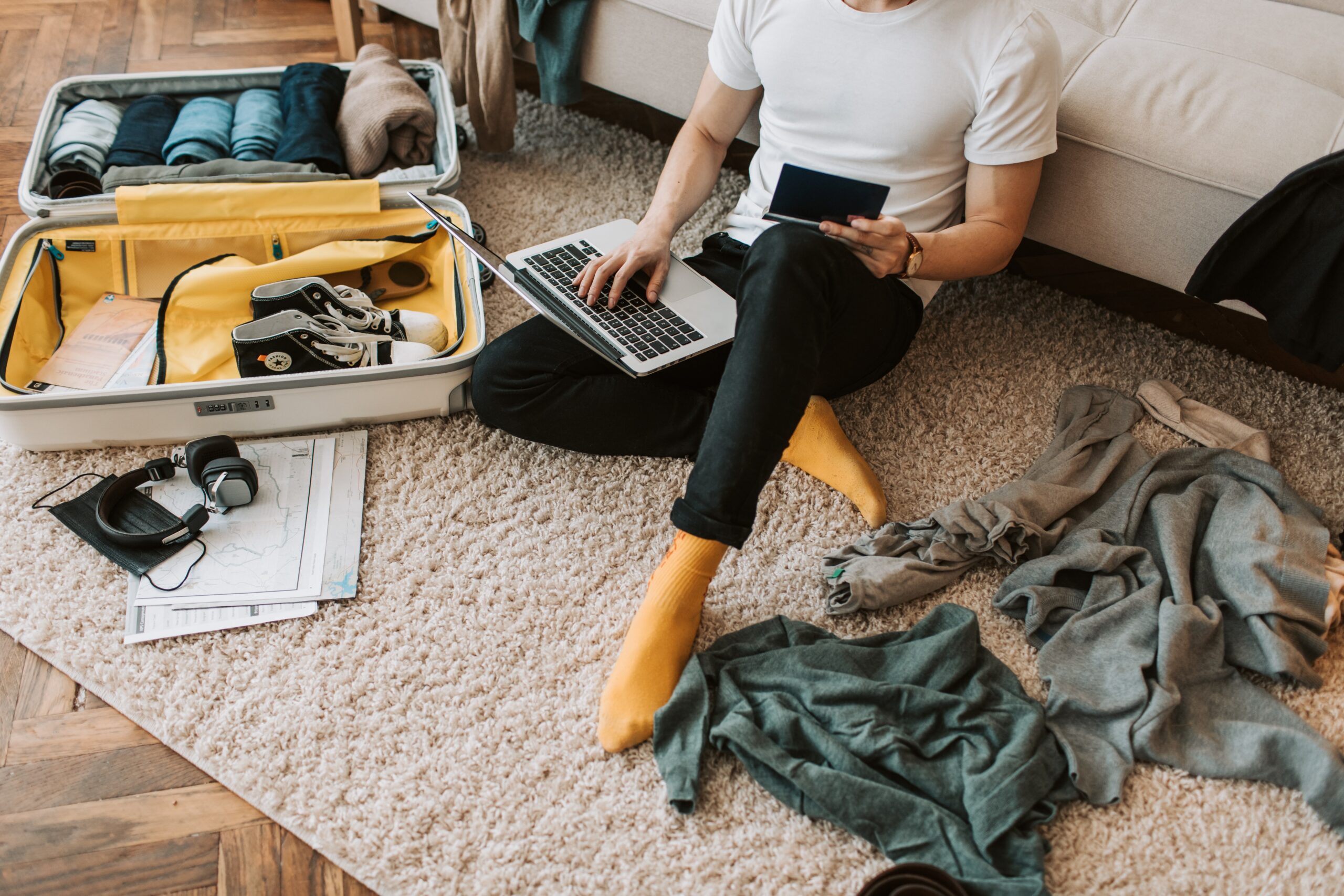 A person sitting on an area rug with laptop