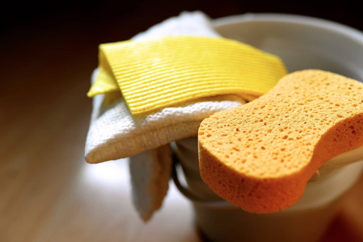 Sponge and rags for cleaning placed on a bucket