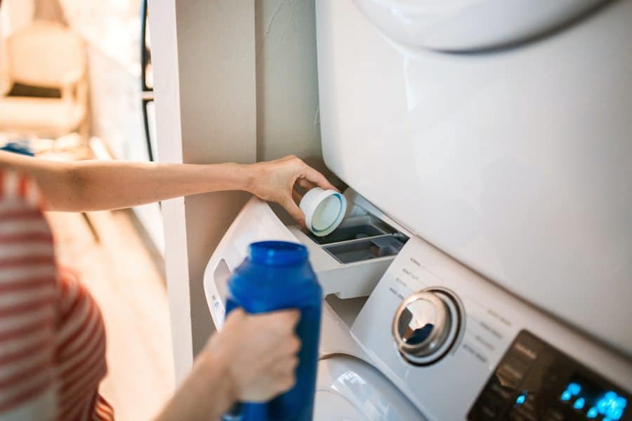 Person pouring out detergent in washing machine