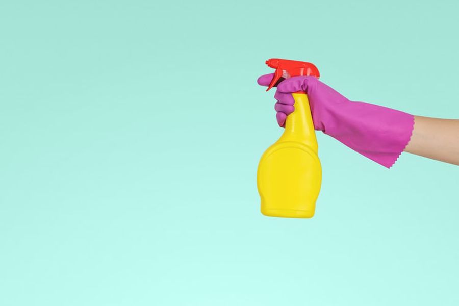 Gloved hand holding a cleaning spray