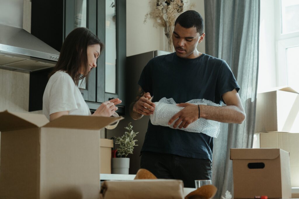 Two persons organizing things with boxes and wrap