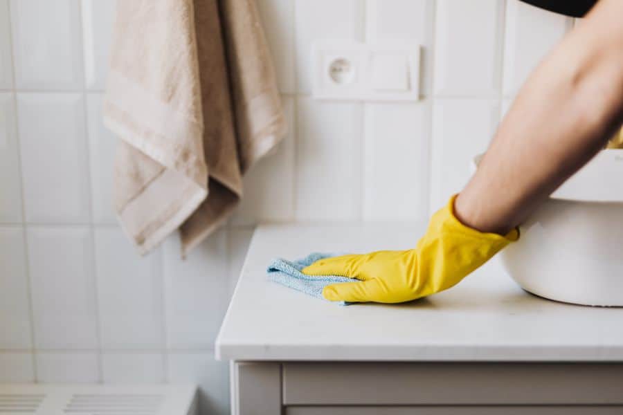 Person cleaning the bathroom countertop