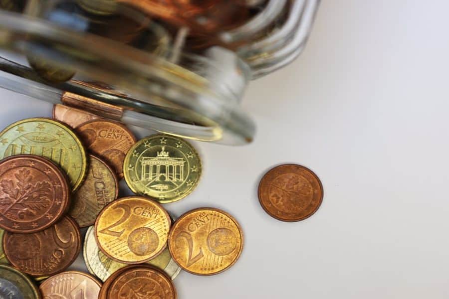 Coins spilling out of a glass jar