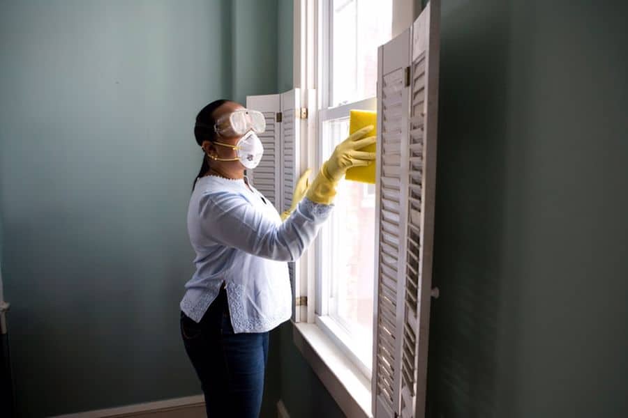 Woman cleaning a double hung window that don't tilt