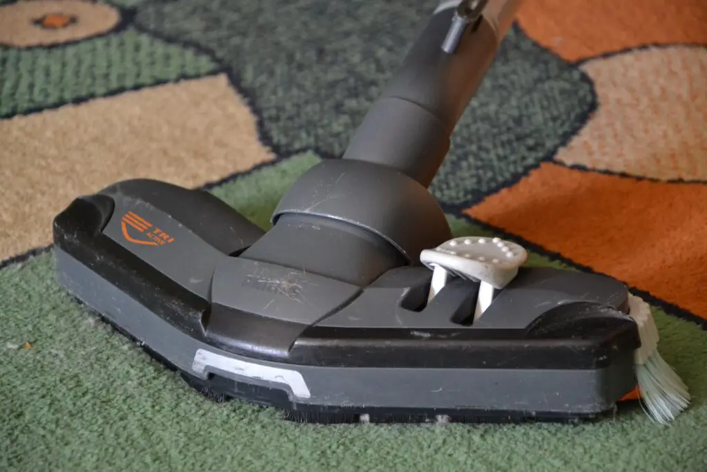 A carpet cleaner with brushes on a multi-toned carpet