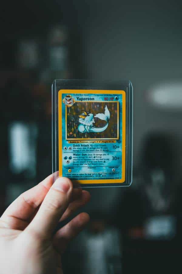 Hand holding a trading card covered with a card sleeve