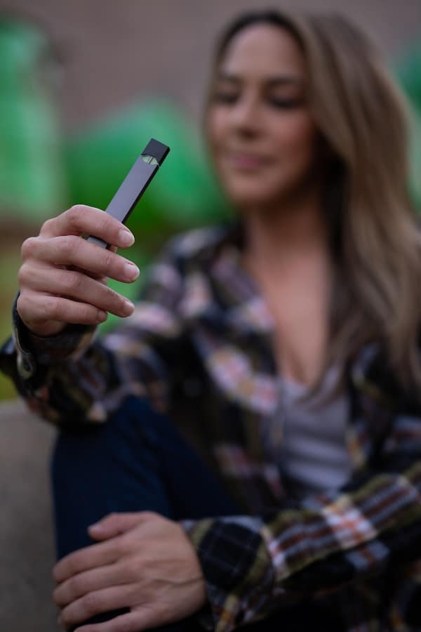 Selective focus of woman holding a Juul