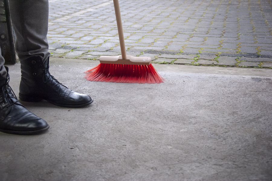 Person sweeping the pavement