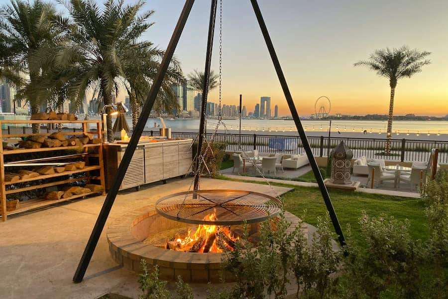 Brown round firepit with green palm trees