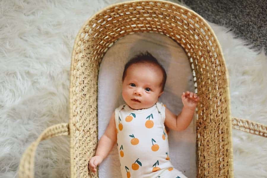 Baby in a onesie lying on a basket
