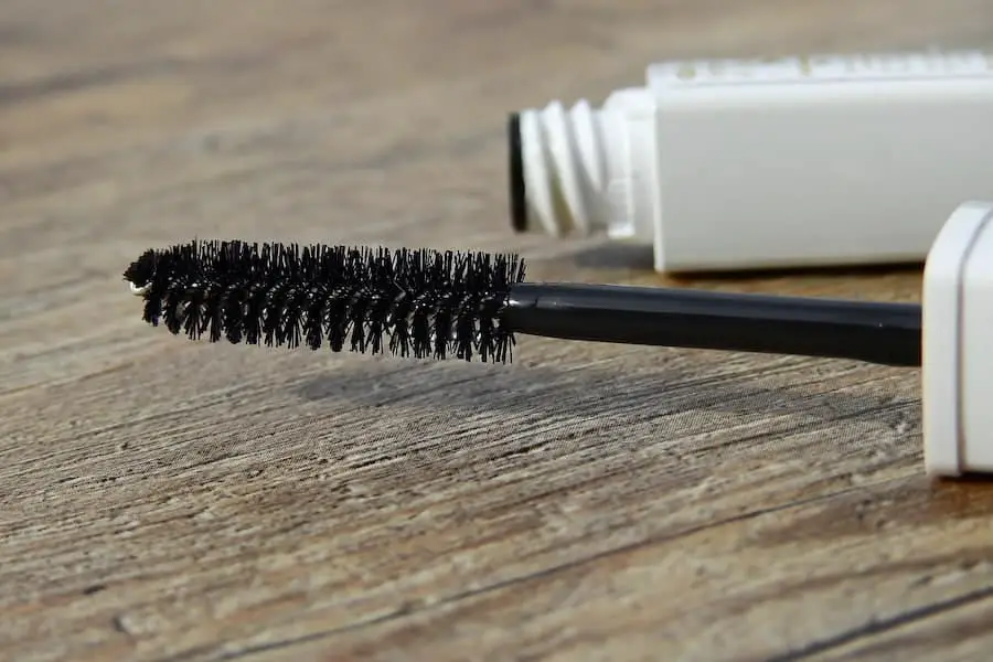 A white mascara brush and tube