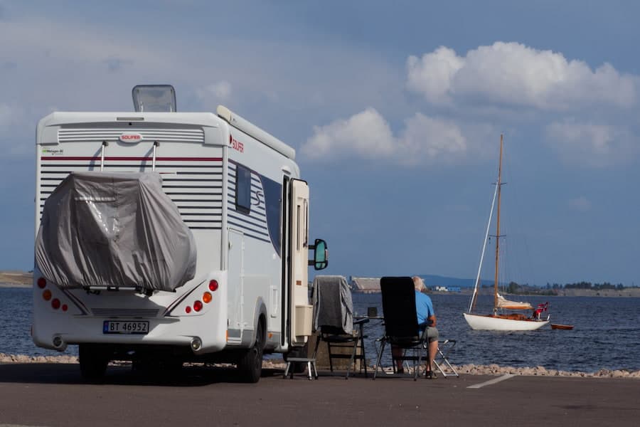 White and gray RV parked near the sea