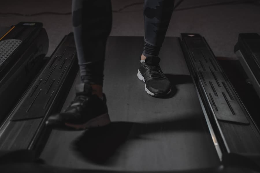 Man walking on a black treadmill belt