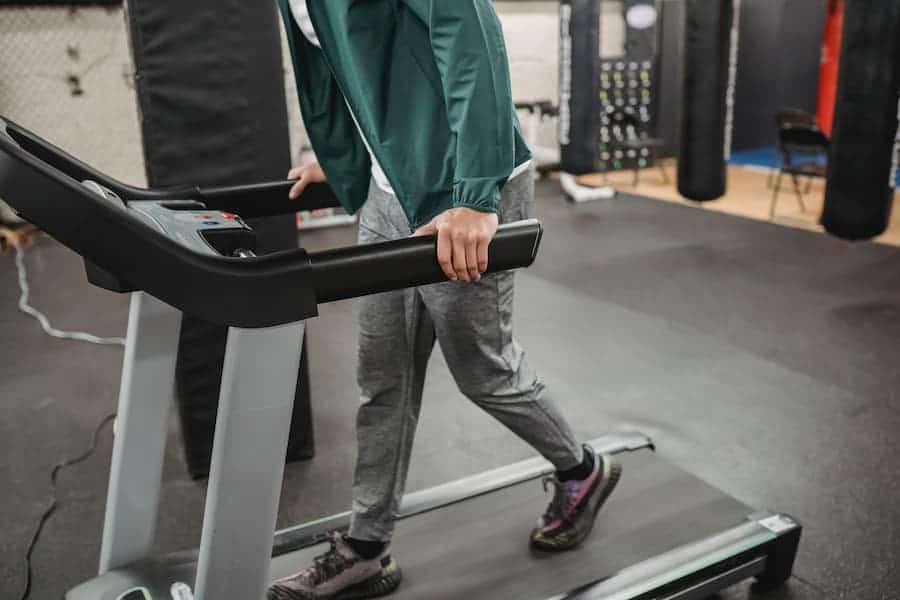 Man walking on a black treadmill belt