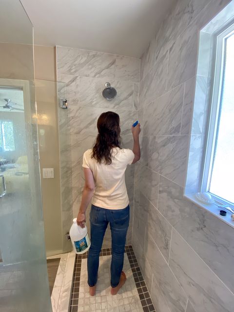 Sara Anne using vinegar to clean her bathroom tiles
