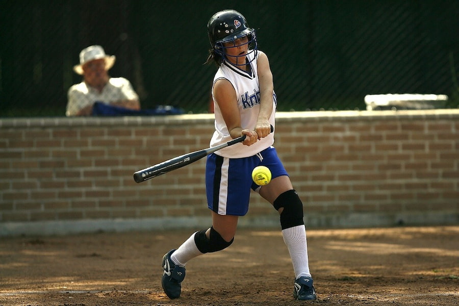 A batter playing with a black softball bat