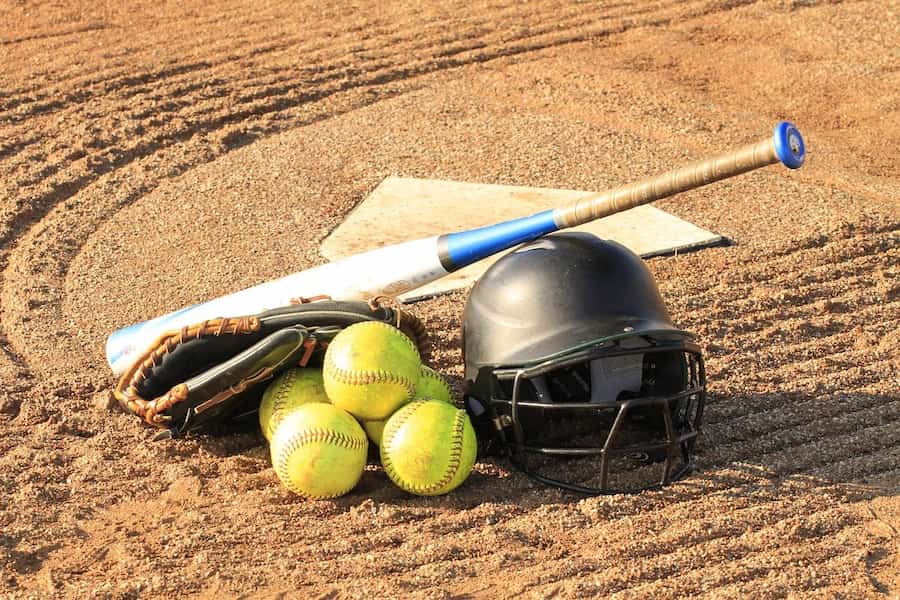 An image of a clean softball bat with helmet and ball