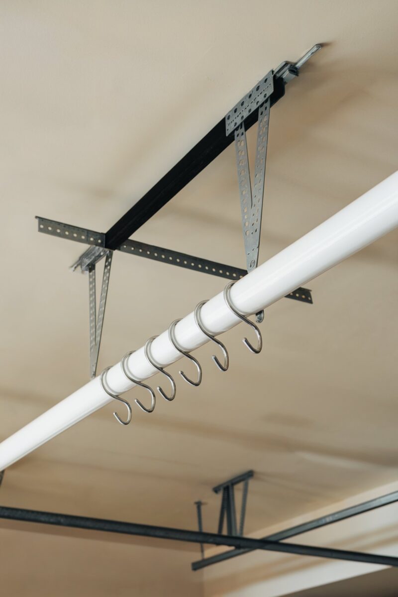 Overhead storage rack with hooks for hanging items