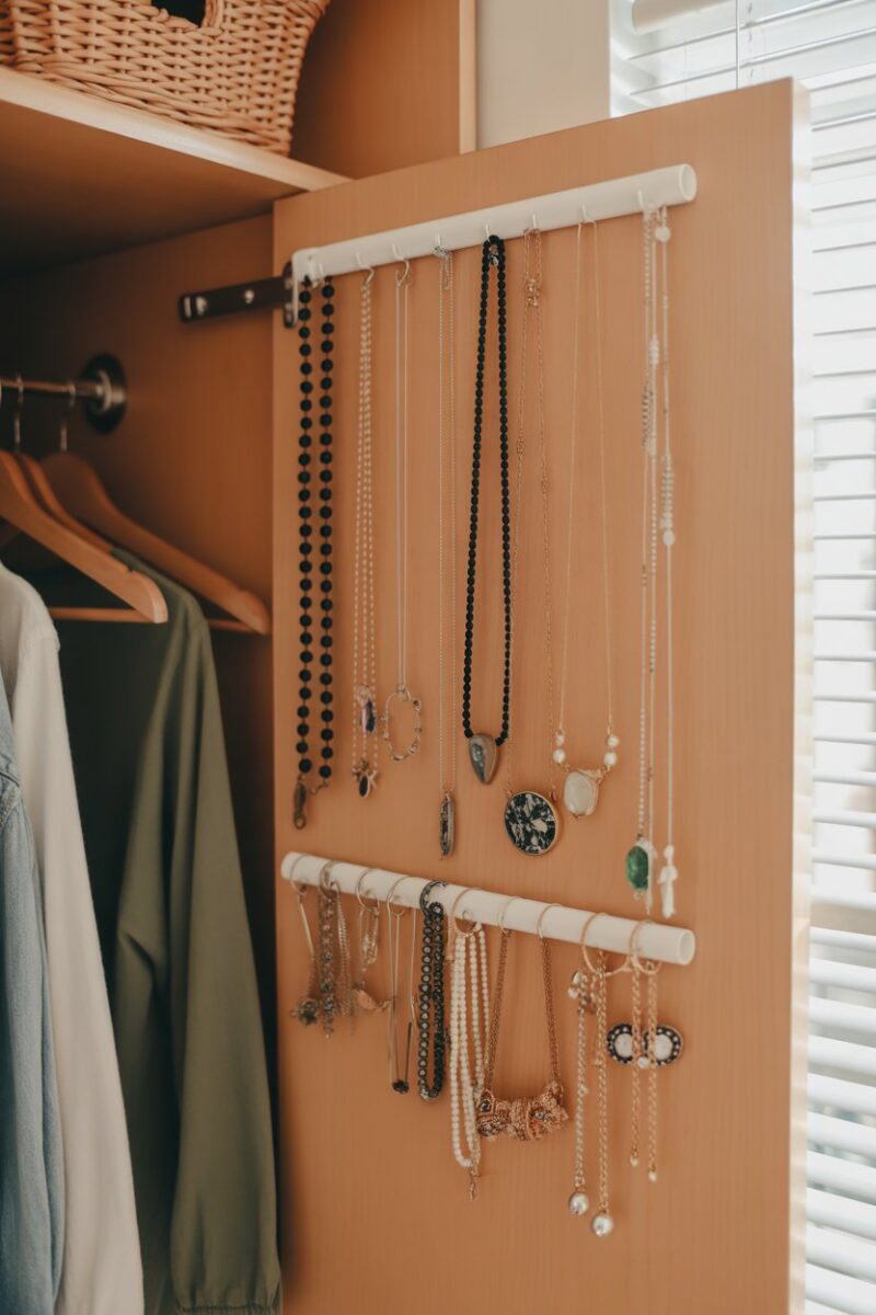 A well-organized jewelry organizer hanging in a dorm closet, showcasing various necklaces and accessories.