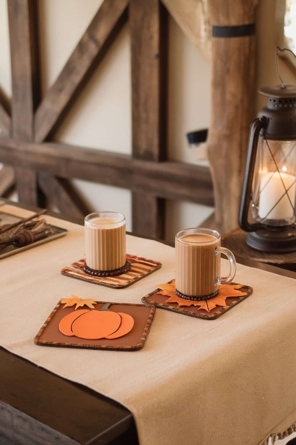 Two cozy fall-themed coasters with drinks on a table