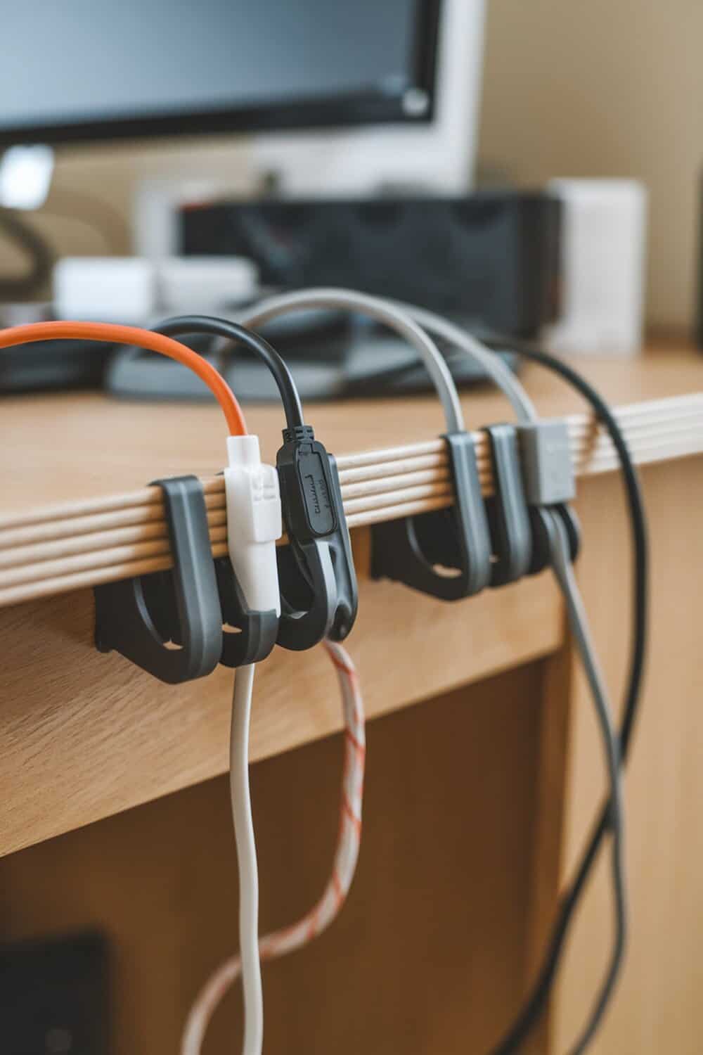 Desk with cable clips holding various laptop cables in place