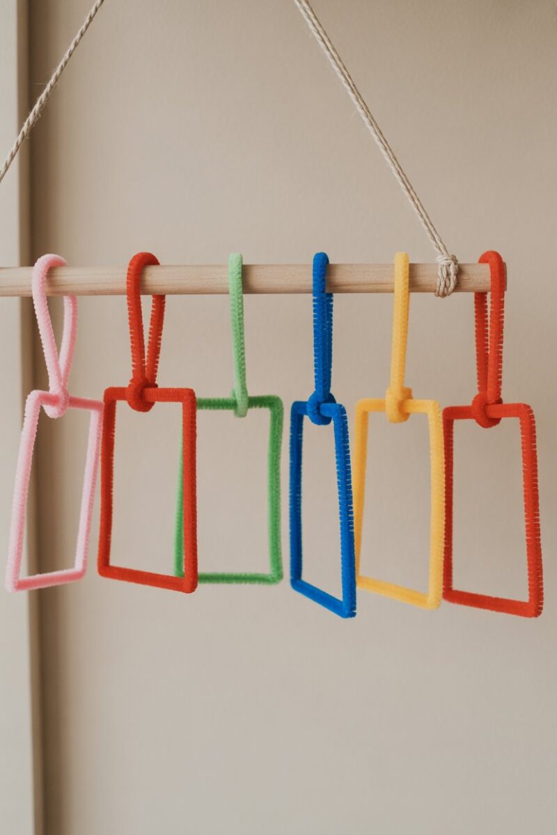 Colorful pipe cleaner gift tags hanging on a wooden rod.