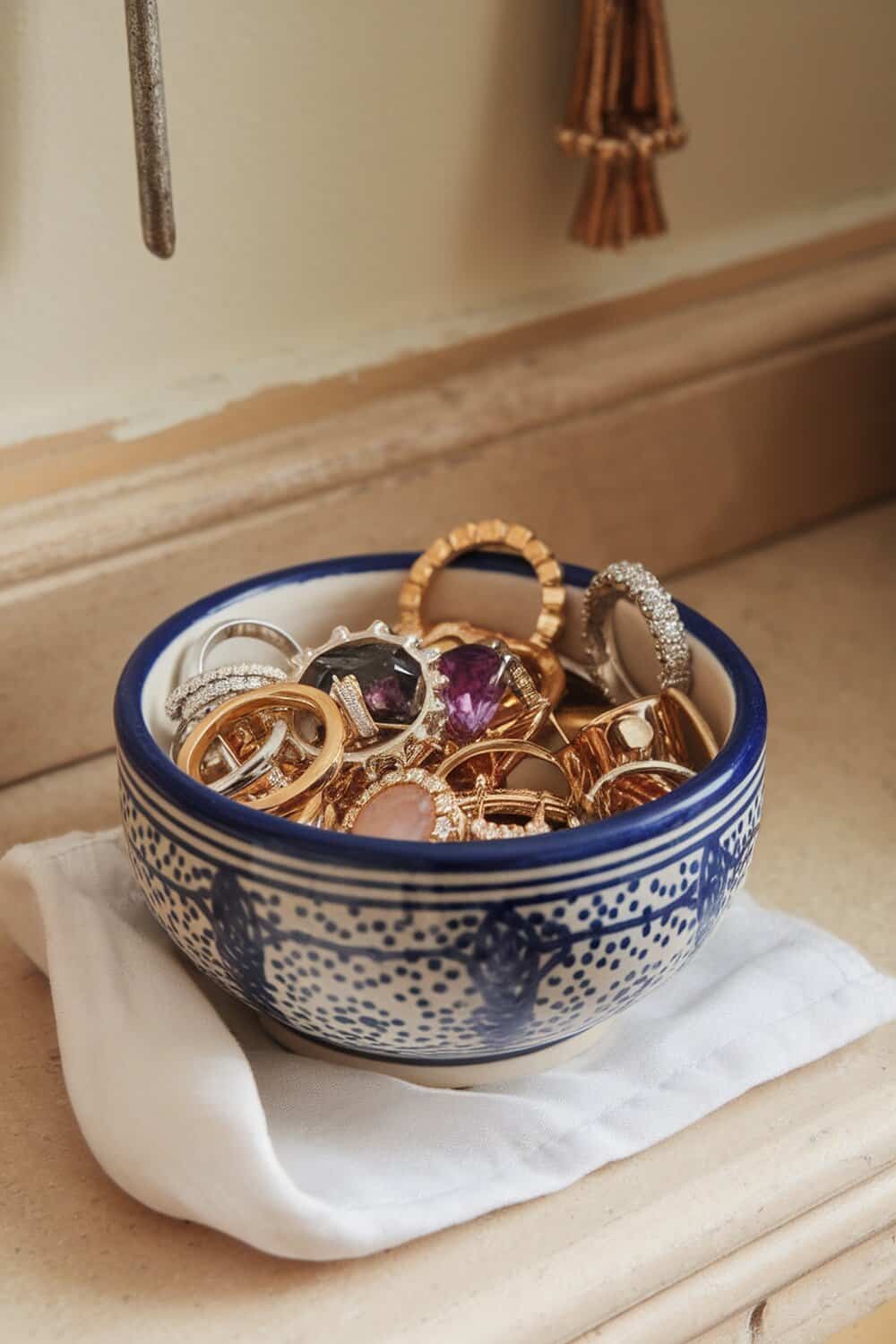 A decorative bowl filled with various rings, showcasing a mix of styles and colors.