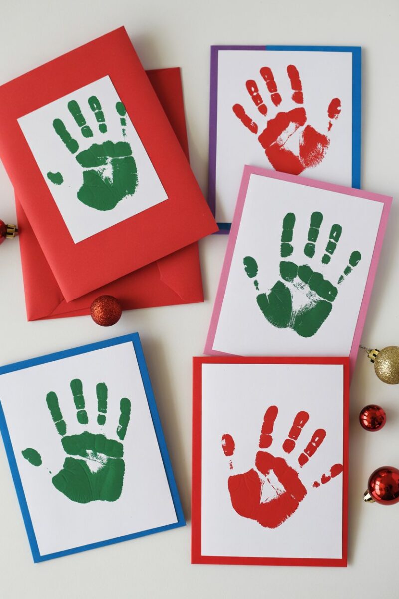 Colorful DIY Christmas cards featuring handprints and festive designs.