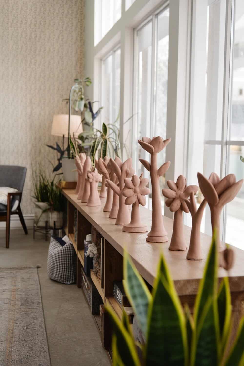 A collection of clay air fresheners shaped like flowers and plants on a wooden shelf.