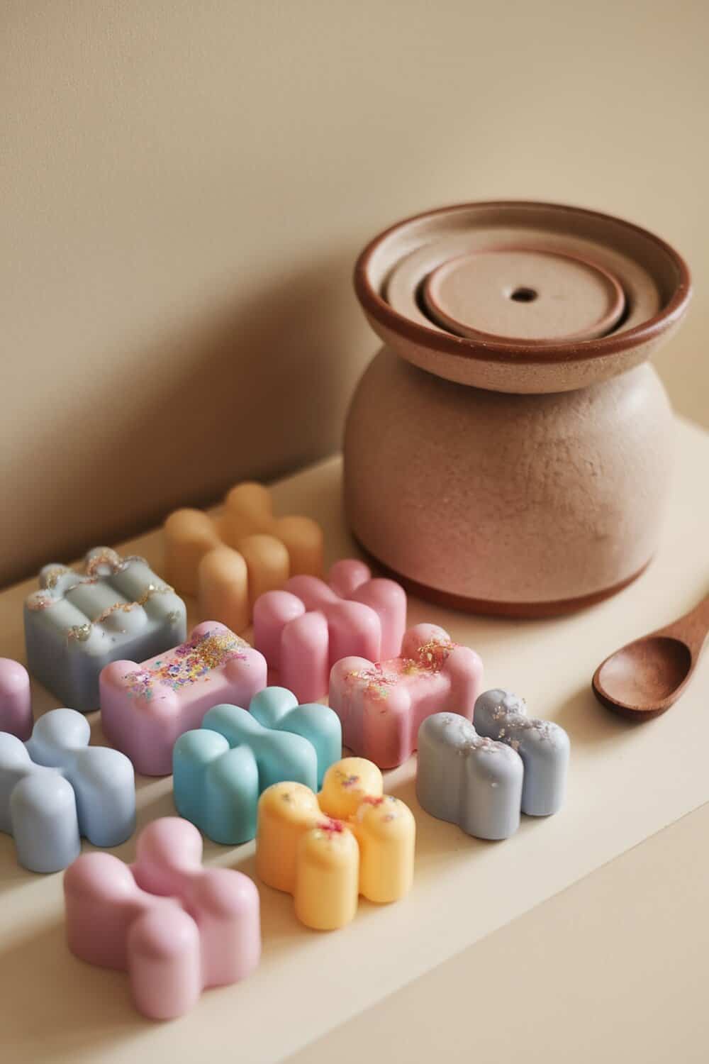Colorful scented wax melts next to a warmer.