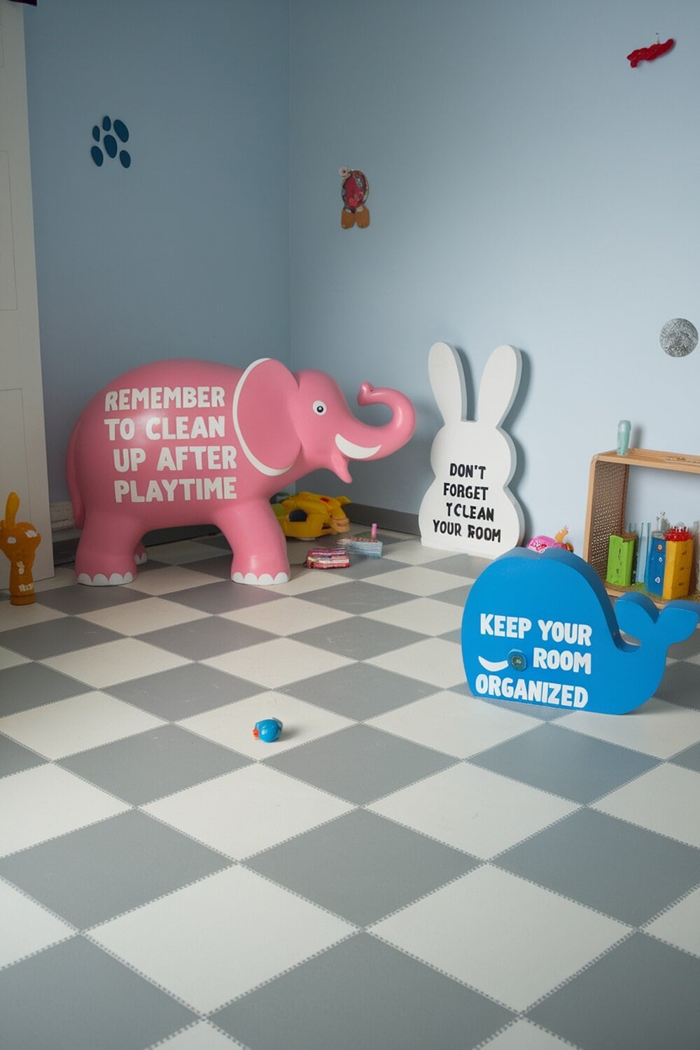 A colorful room with playful decorations including a pink elephant, a white bunny, and a blue whale, all encouraging cleanliness.