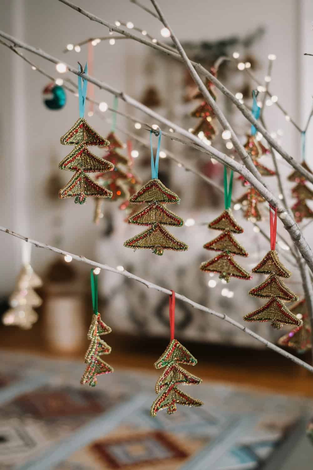Colorful beaded Christmas tree decorations hanging on a branch.