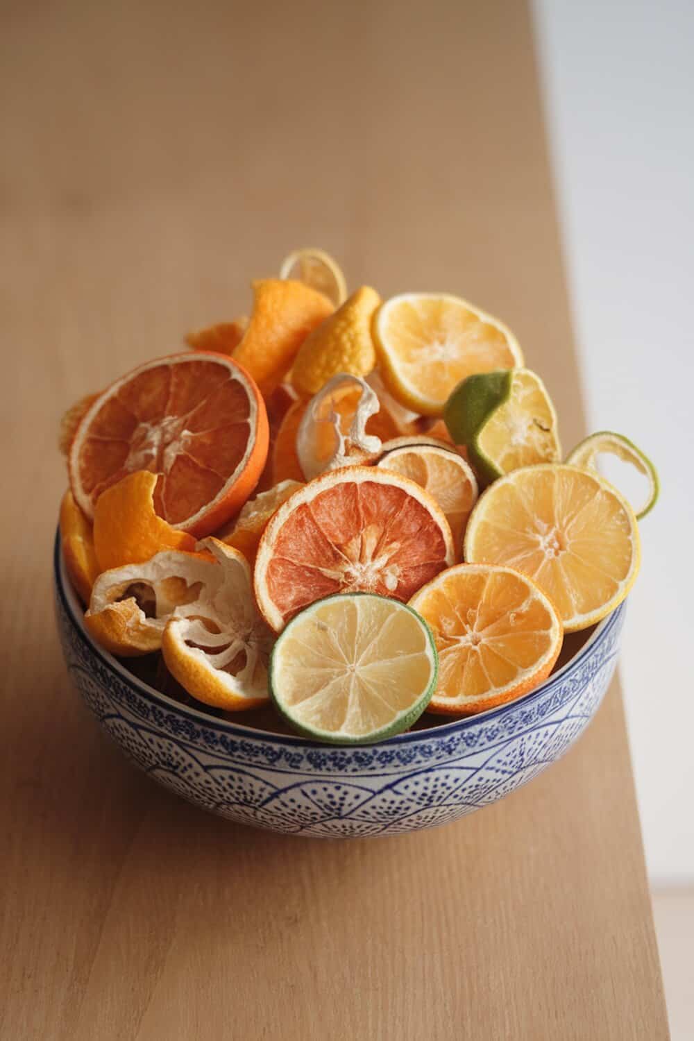 A bowl filled with dried citrus fruit peels on a wooden surface.