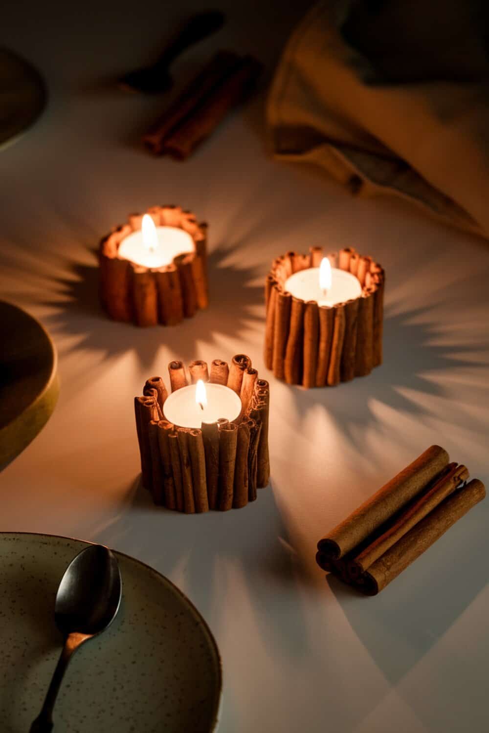 Cinnamon stick candle holders with lit candles