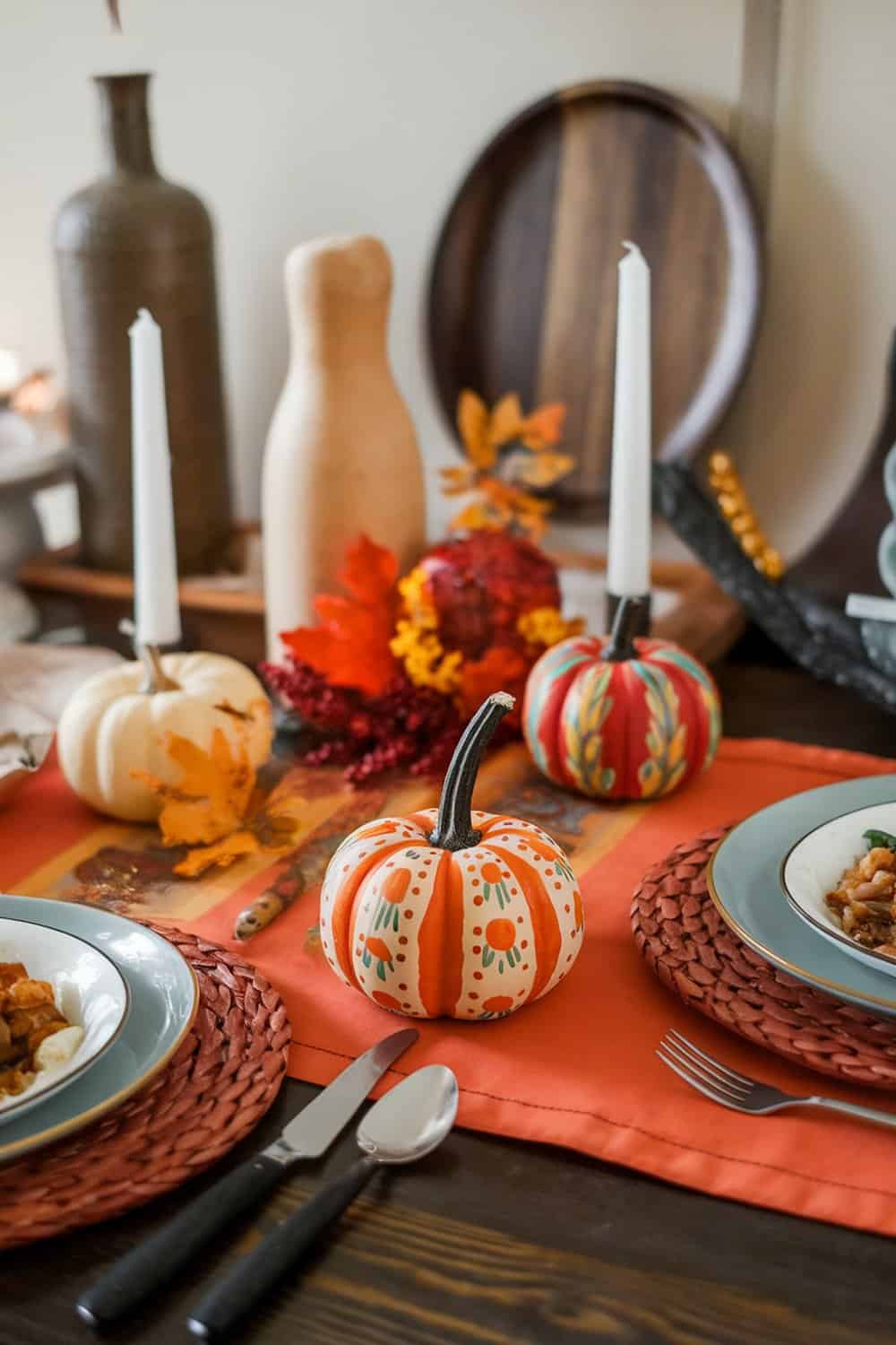 Colorful painted pumpkins used as place holders on a Thanksgiving table.