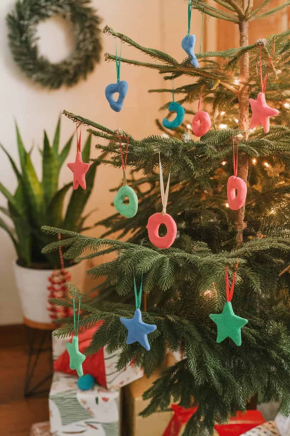 Colorful salt dough ornaments hanging on a Christmas tree.