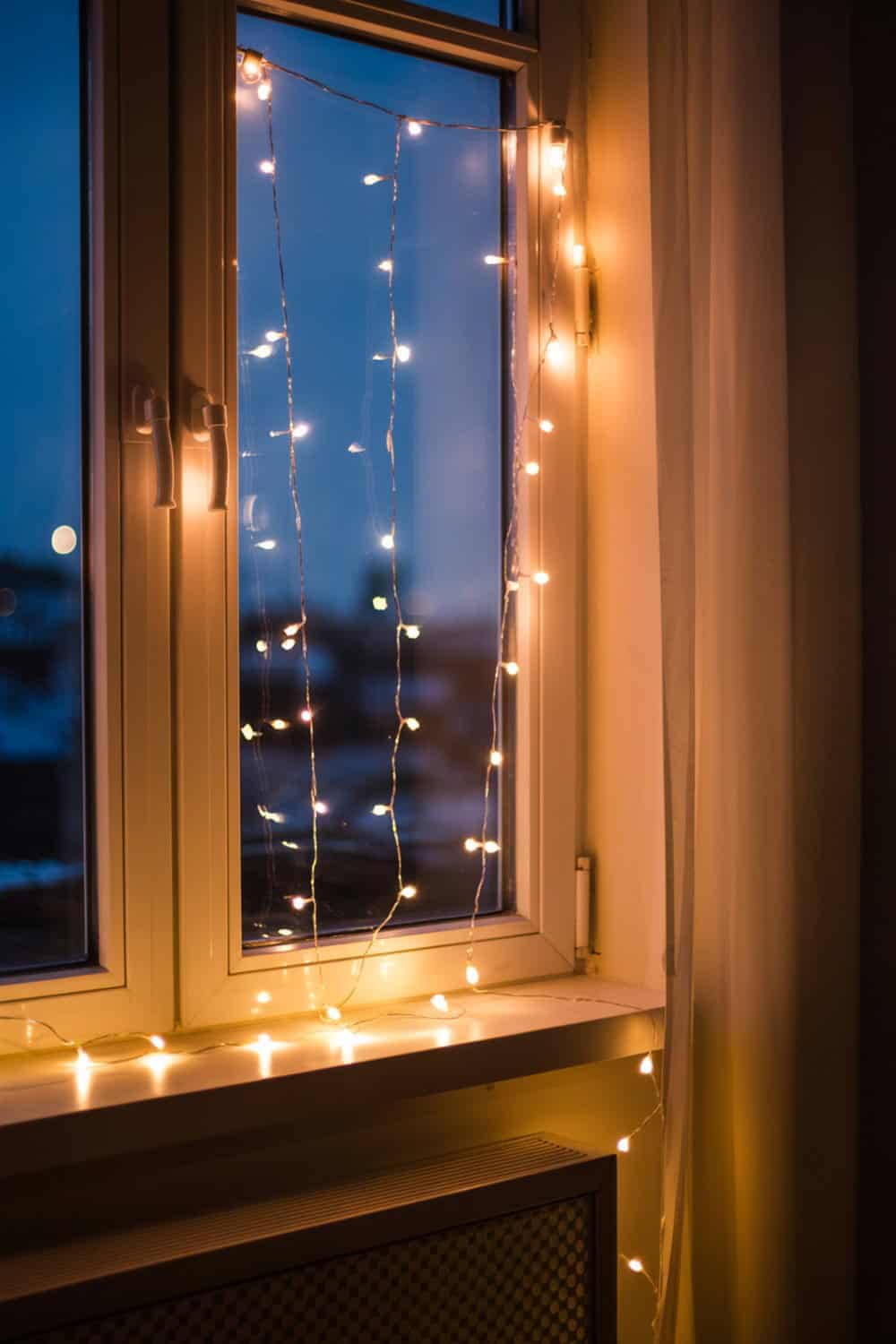 A window decorated with twinkling fairy lights, creating a warm and inviting atmosphere.