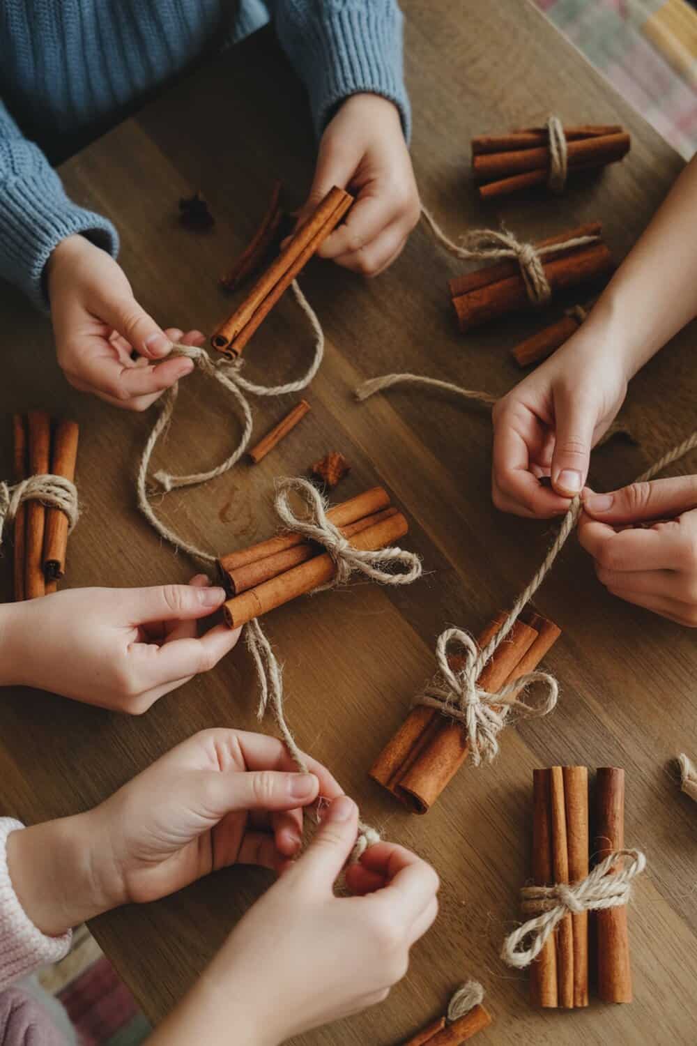 Kids making cinnamon stick ornaments for Christmas