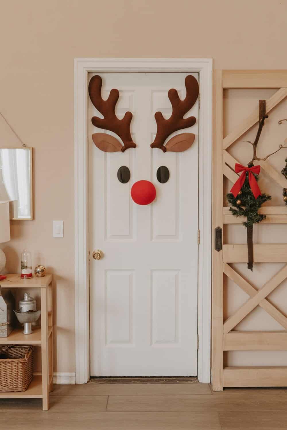 A door decorated as a reindeer with antlers, eyes, and a red nose.