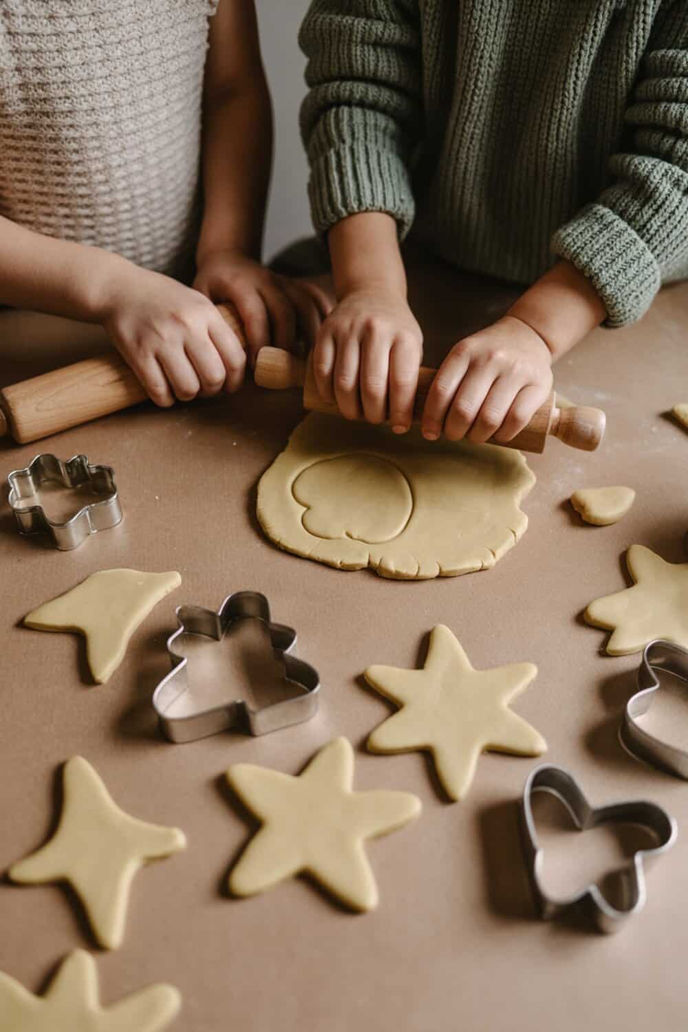 Kids rolling out salt dough and using cookie cutters to make ornaments.