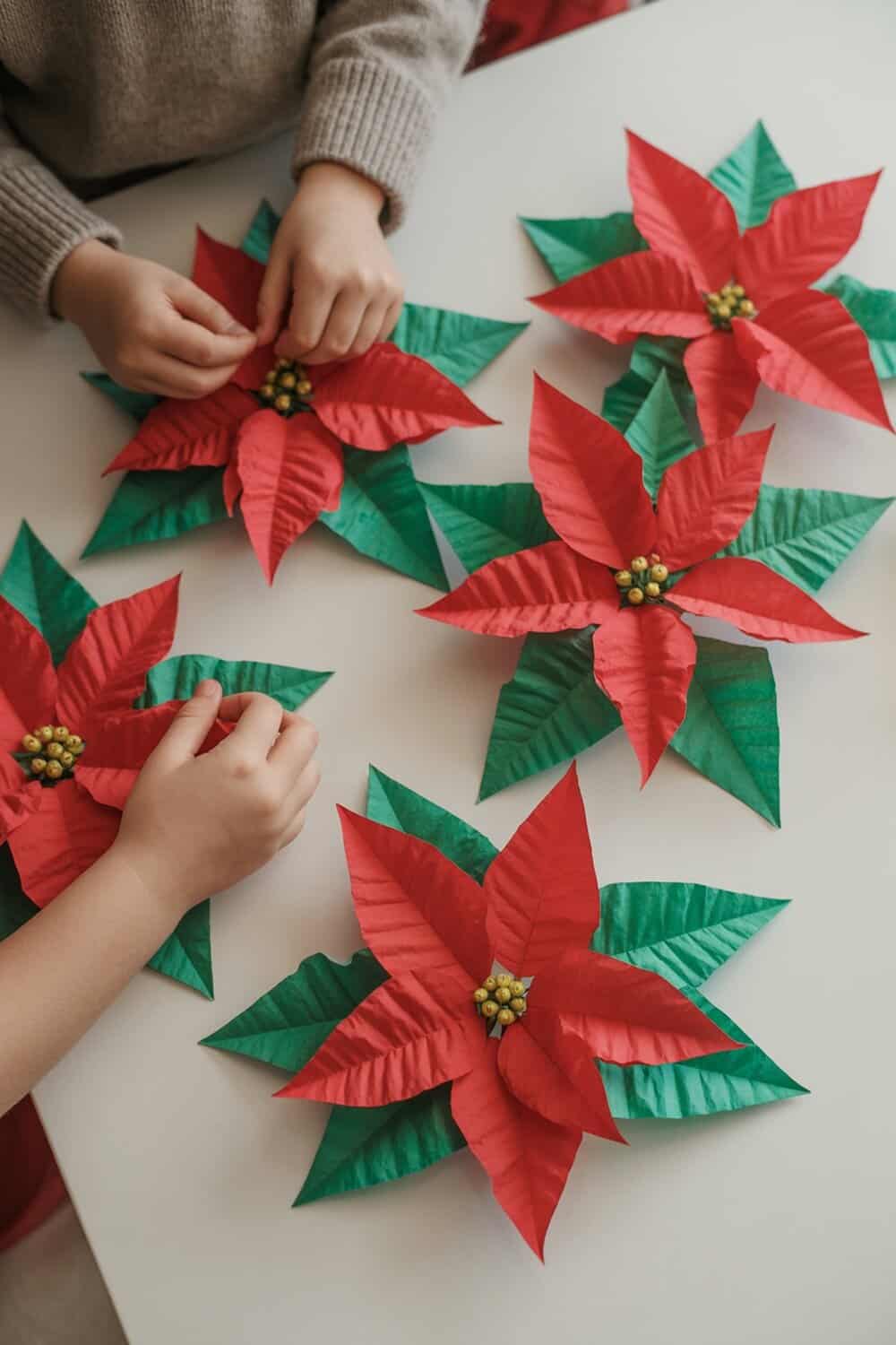 Children making tissue paper poinsettias for Christmas decorations.