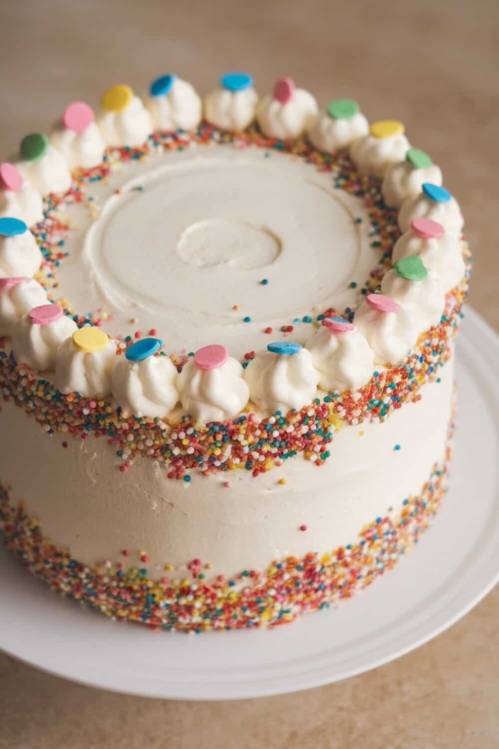 A beautifully decorated confetti cake with colorful sprinkles and frosting.