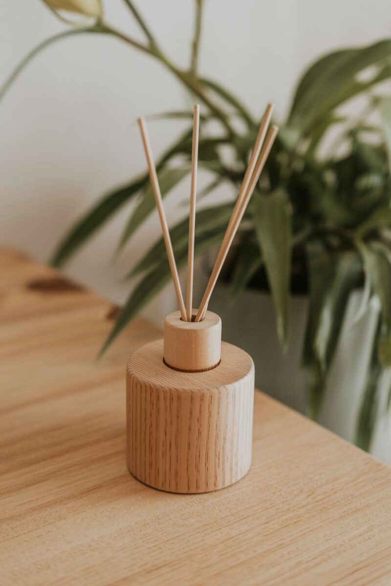 A wooden container with essential oils and reed sticks for a natural air freshener.