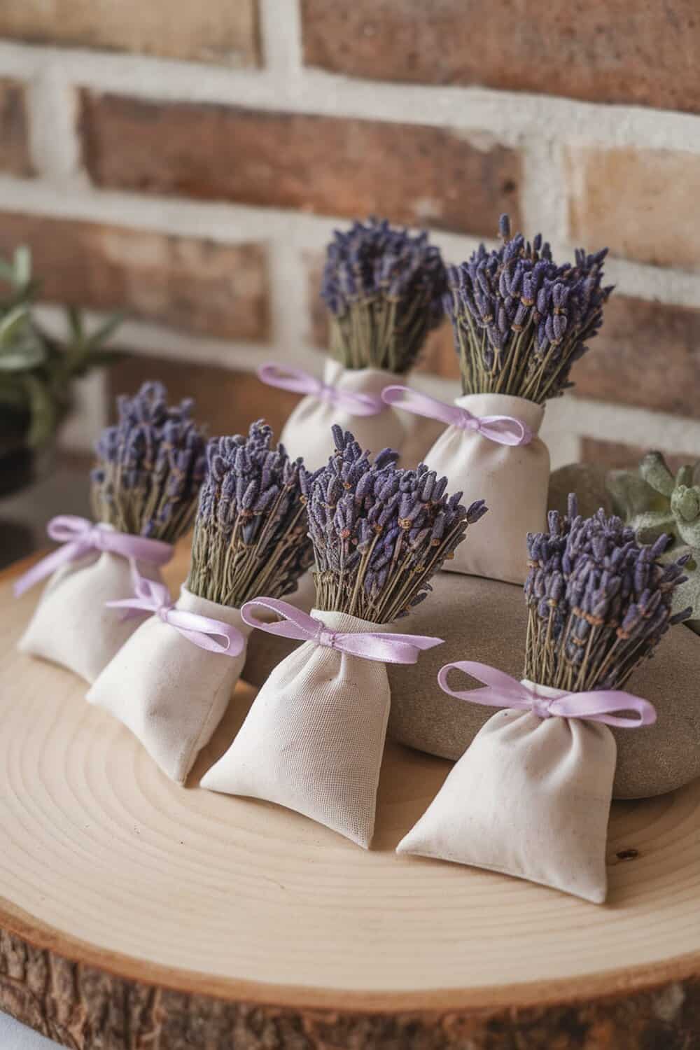 Small fabric sachets filled with dried lavender, tied with ribbons, displayed on a wooden surface.