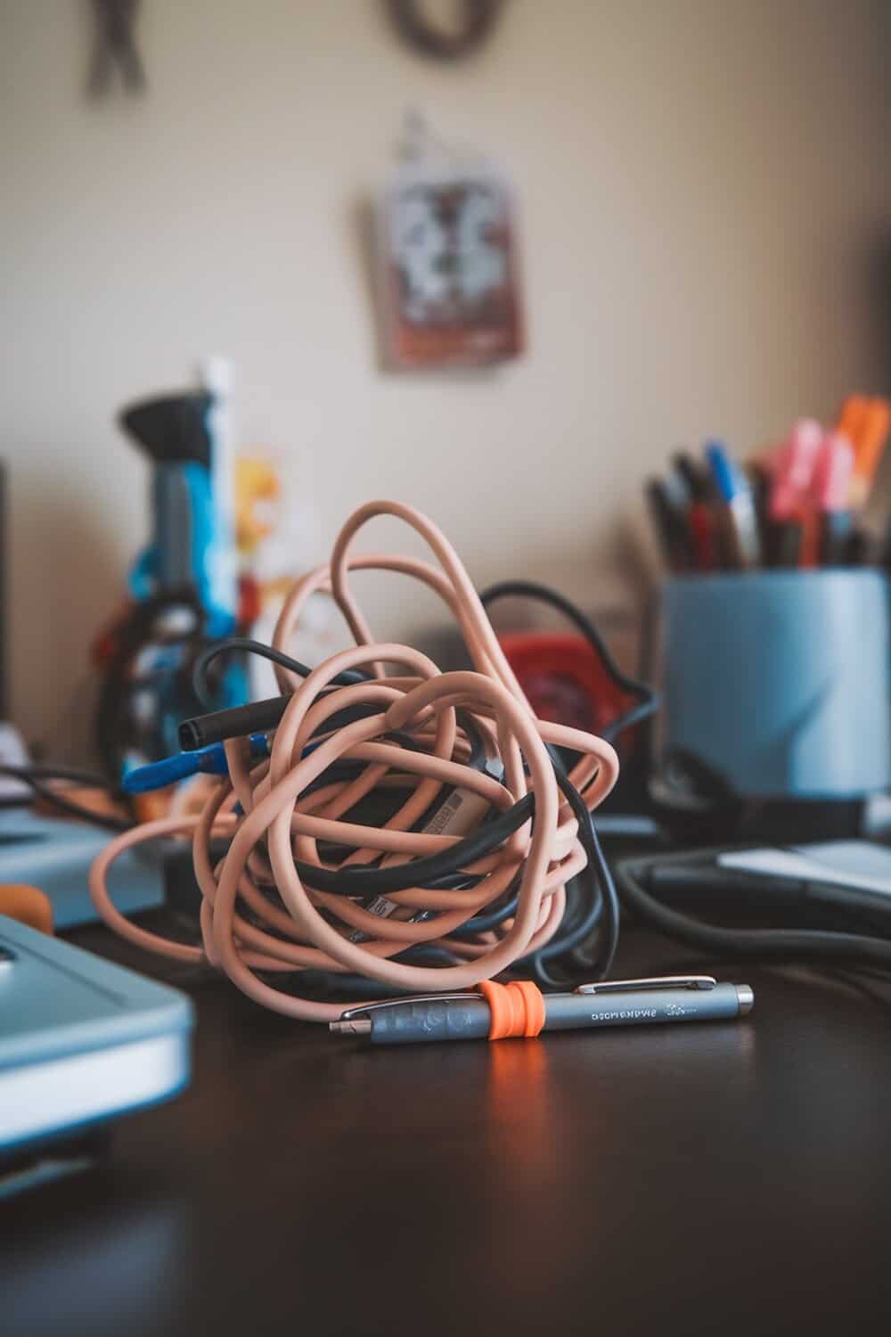 A tangled mess of cords and chargers on a desk.